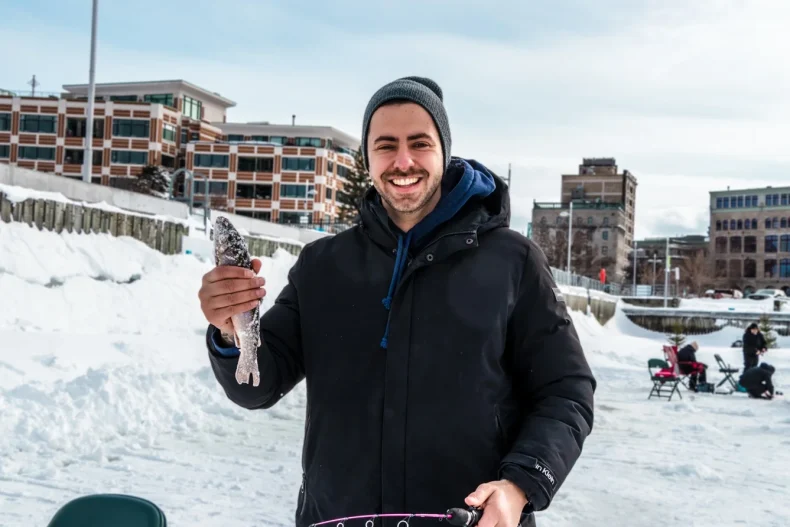 Image of a men holding a freshly caught fish in his hand