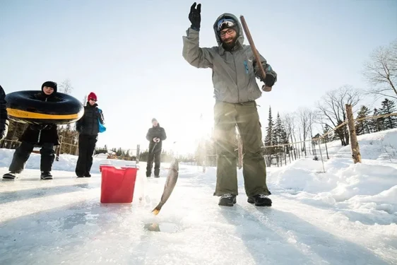 Image of a group of people looking at a men ice fishing