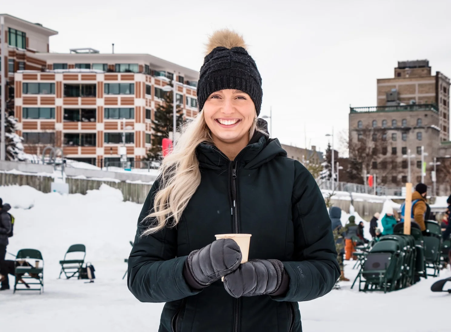Image of a women smiling while holding a hot chocolate