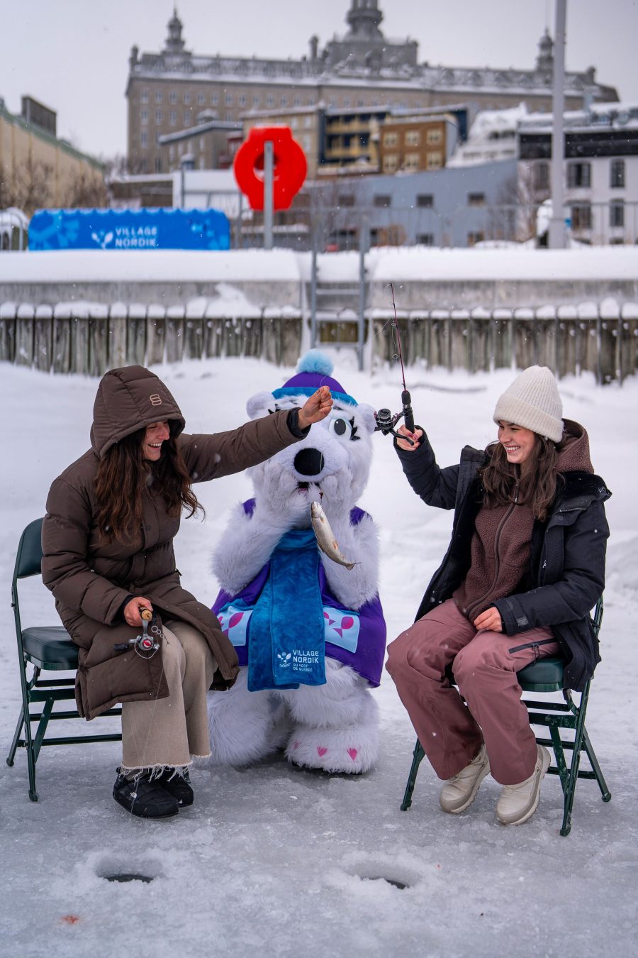Deux filles et Louise l'ourse polaire qui pêchent un poisson