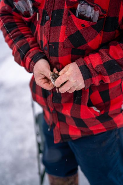 photo de proche d'un homme qui enlève le hameçon de la bouche d'un poisson